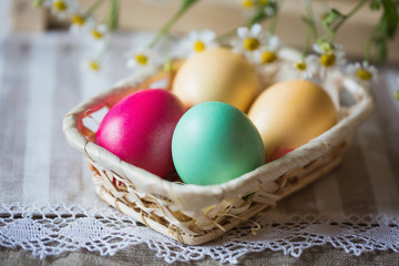 Painted easter eggs in a basket on a limen napkin