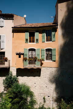 orange house with green shutters in France.