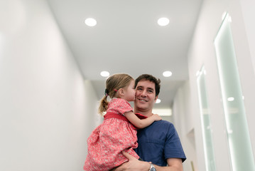 Dentist doctor with little girl on hands