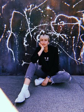 Portrait of a woman sitting in front of a splash of paint