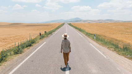 Woman walking by the empty highway
