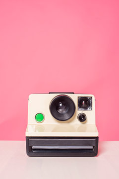 Old Polaroid Camera On Pink Background.