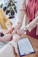 cropped view of man and women giving fist bump in office