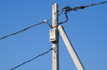 Fototapeta premium Electro-bolt with a counter and wires, a torsad on a pole.