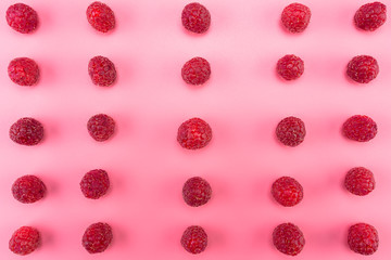 Pattern made from fresh raspberries, top view, flat lay pattern, isolated on a light pink background.