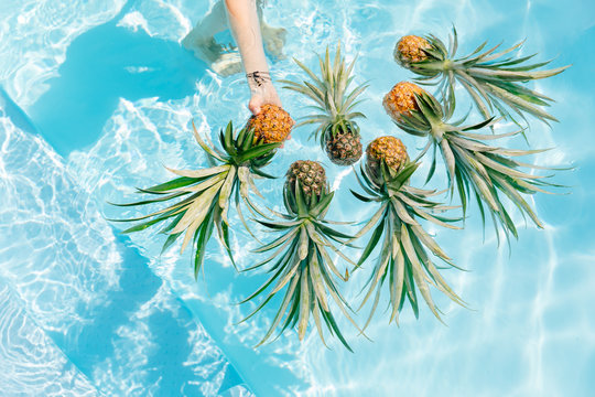 Woman taking pineapple in the pool
