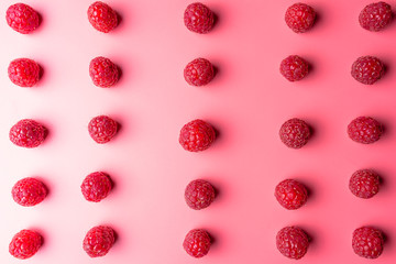 Pattern made from fresh raspberries, top view, flat lay pattern, isolated on a light pink background.
