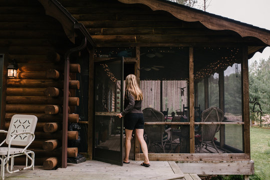 Woman Entering Cabin Porch