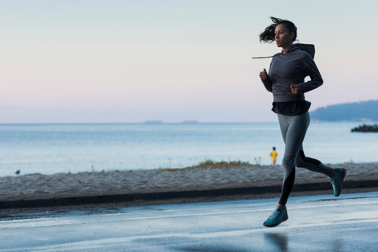 Young attractive woman in good shape jogging early in the morning