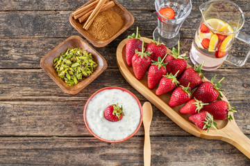 Strawberries and cinnamon in a bowl on the wooden rustic table