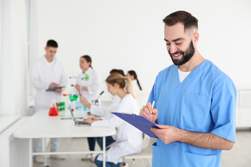 Fototapeta premium Portrait of medical student working in scientific laboratory. Space for text
