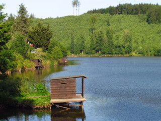 Wooden fishing huts near the lake, sport fishing, summer activities