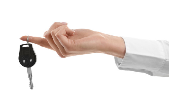 Woman holding car key isolated on white