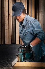 Young woman  using modern electric  saw in the workshop