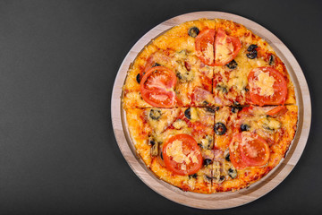 Tasty pizza on a black background. Top view of hot pizza. Flat lay. Banner