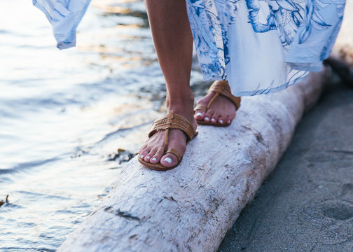 Close up shots of girl wearing sandals by the beach at dusk