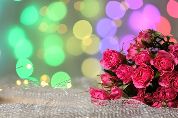 Fresh bouquet on mesh fabric against blurred lights, space for text. Bokeh effect