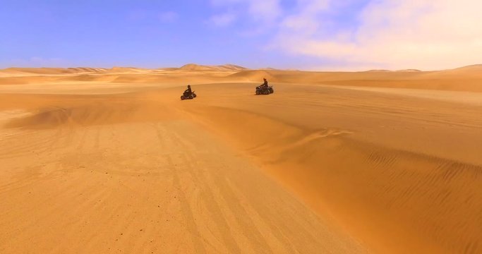 NAMIB-NAUKLUFT NATIONAL PARK, NAMIBIA. Tourists ride ATVs along the Namib Desert. Aerial 4K shot of the highest dunes worldwide.