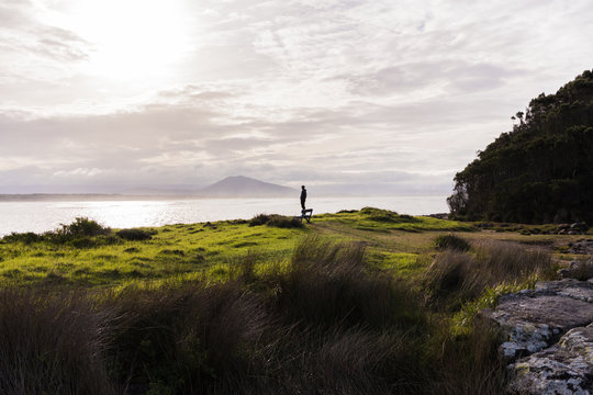A man stands by the Australian coast looking out over the waves