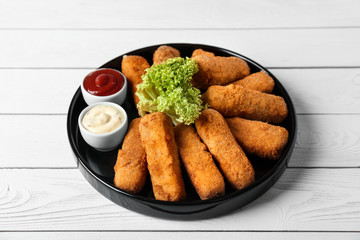 Plate of cheese sticks and sauces on table