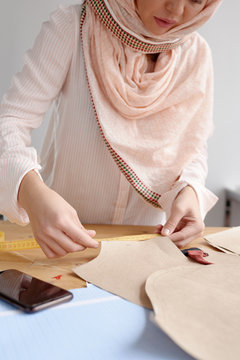 Woman with measuring tape and sewing pattern