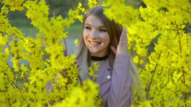 Spring time and happy girl on the landscape of yellow flowers