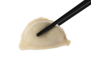 Chopsticks with boiled dumpling isolated on white