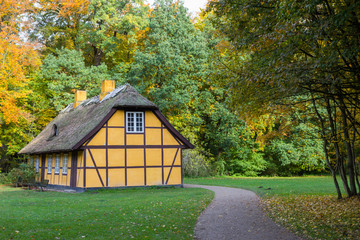 Old yellow half timbered house with thatched roof in Charlottenlund forest, Denmark