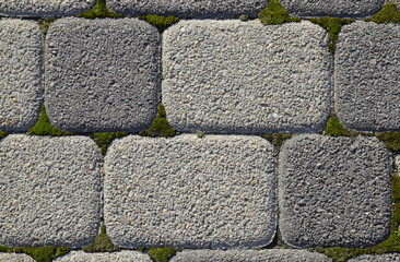 Industrial building background of paving slabs with overgrown with moss in the cracks. Texturing background
