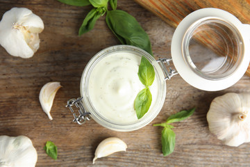 Flat lay composition with garlic sauce on wooden background