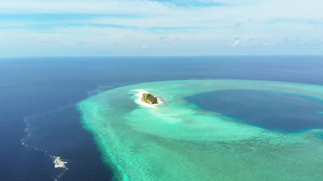 Aerial: Flying over idyllic atoll, scenic travel destination in Wakatobi National Park Indonesia Maldives Polynesia blue lagoon turquoise water coral reef desert island white sand beach