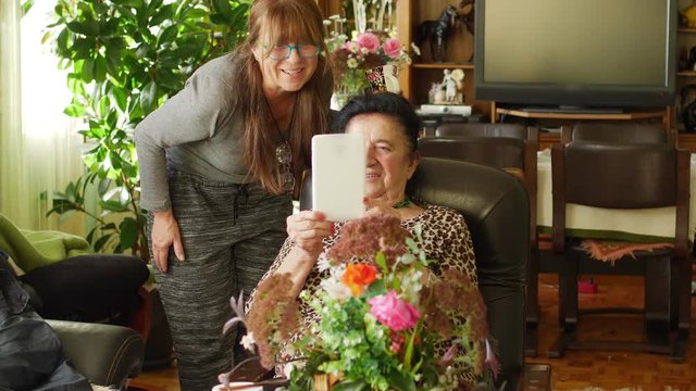 Grandmother having fun chatting with grandchildren on skype at home