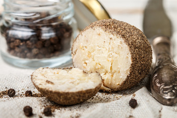 Delicacy round small cheese with black pepper and garlic. Belper knolle. Spicy appetizer for gourmets. Selective focus