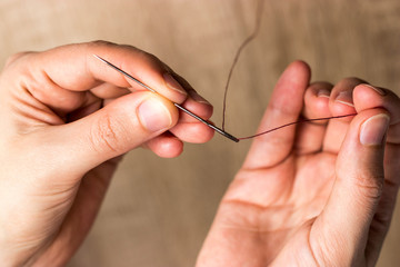 Hands with needle and thread