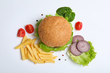 Composition with burger and french fries on white background