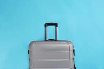 Stylish suitcase on color background, top view