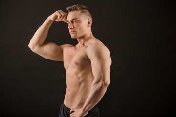 handsome man with muscles on a black background