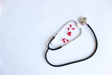 Medical stethoscope, stethoscope and red pills. Pills and treatments.