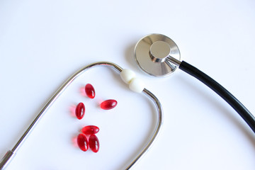Medical stethoscope, stethoscope and red pills. Pills and treatments.