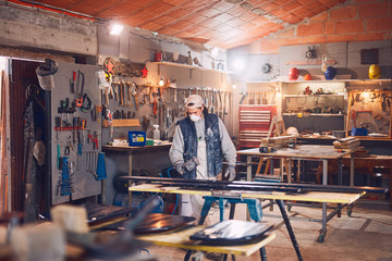 Male carpenter working on old wood in a retro vintage workshop.