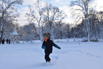 Fototapeta na wymiar Kid playing in the snow winter time