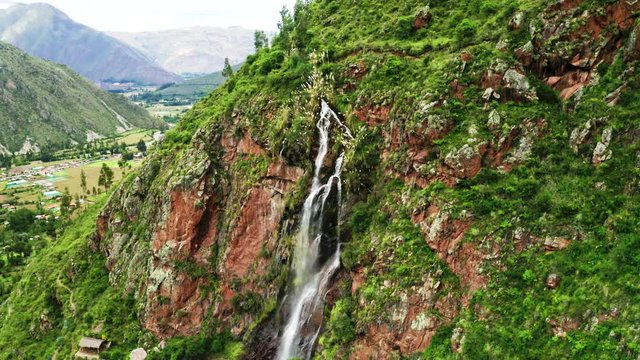 Beautiful Arin waterfall stream in a mountain in the Sacred Valley, Urubamba near Cusco in Peru. Nature and peaceful landscape in a valley in the Andean mountain range.