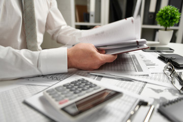 Businessman working at office and calculating finance, reads and writes reports. Business financial accounting concept.
