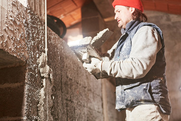 Fototapeta premium Real construction worker making a wall inside the new house.