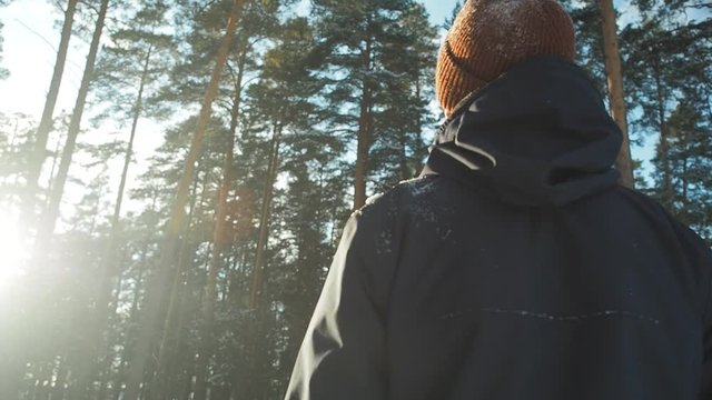 Man photographer walking winter forest trail. Beautiful sunny day, hipster filter. Sports recreation activity winter holiday vacation tourism. Man photographer exploring forest with camera