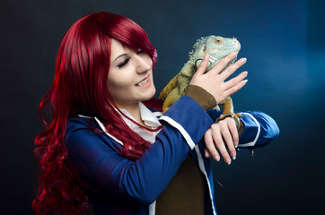 cosplay anime girl and green iguana in studio. halloween