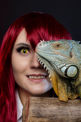 cosplay anime girl and green iguana in studio. halloween