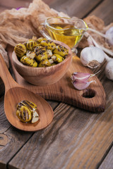 Grilled olives with garlic, olive oil and spices on rustic wooden table