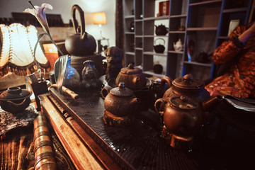 Caucasian master in kimono making natural tea in the dark room with a wooden interior. Tradition, health, harmony. Chinese tea ceremony