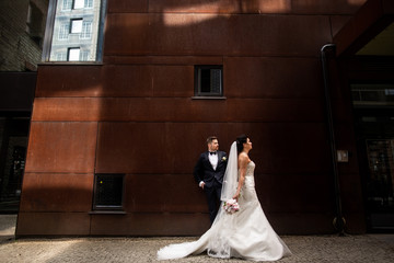 Bride and groom walking in the city, wedding day, marriage concept. Bride and groom in urban...